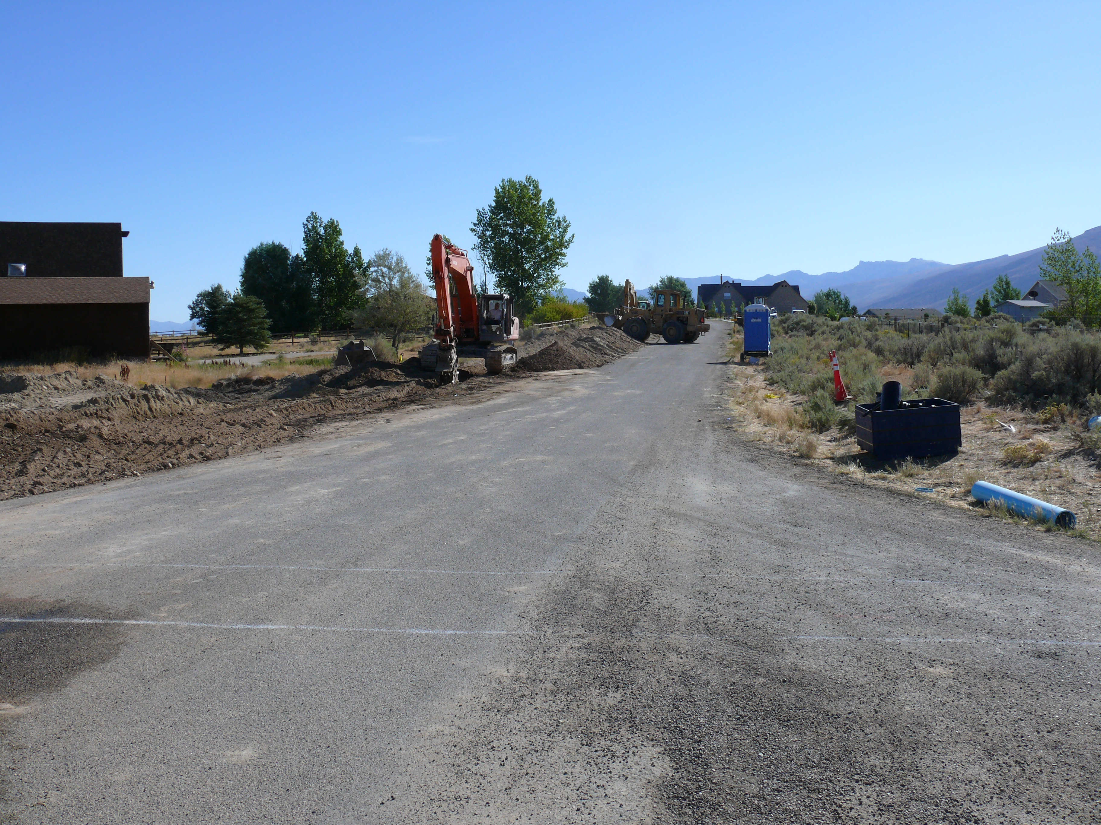 Excavator performing roadway reconstruction